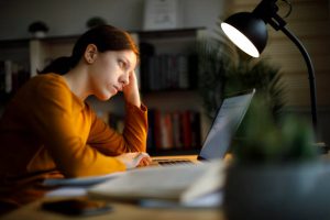 Worried teenage girl studying late at home stock photo