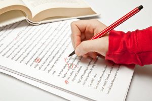 Proofreader at work, working in a novel and using professional proofreader signs. Proofreading concepts Lightbox: